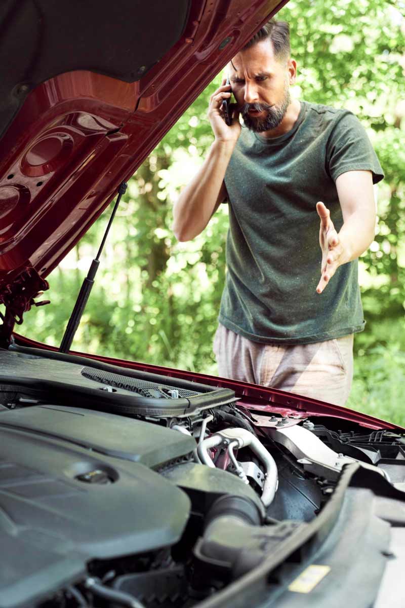 Junger Mann prüft Getriebeschaden bei Schrottauto Ankauf Kleve